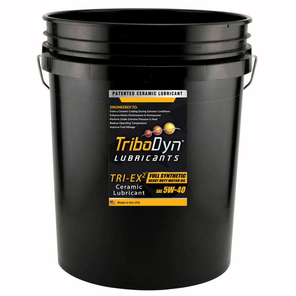A black five gallon bucket with a label for TriboDyn 5W-40 TRI-EX2 Full Synthetic Heavy Duty Diesel Engine Oil with ceramic coating