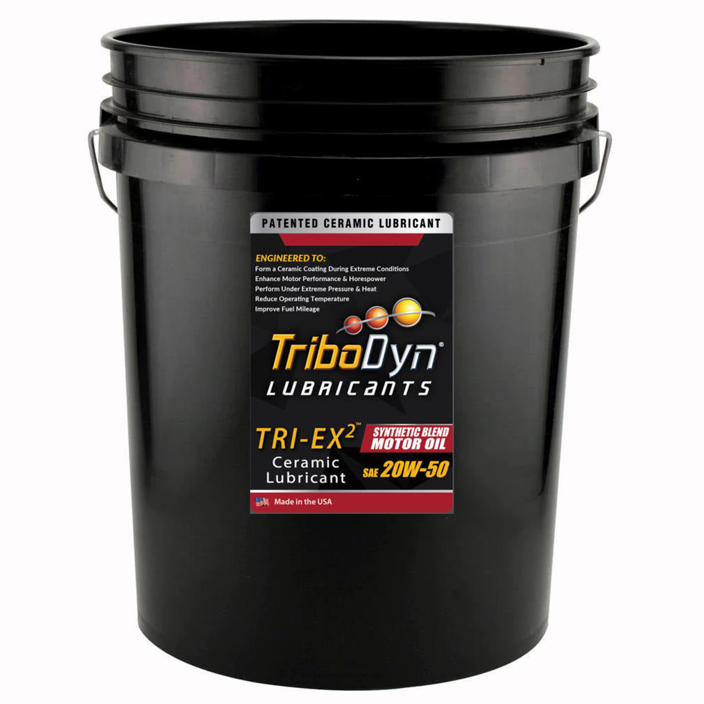 A black 5 gallon bucket with a label for TriboDyn TRI-EX 2 Synthetic Blend 20W50 Oil with Ceramic Coating
